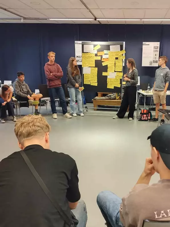 Gruppenbild im Stuhlkreis mit Metaplanwand
